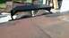 2016 Ford F-250 - A rusty truck cab sits behind a trailer deck with a black metal ramp.