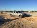 2004 Ford F-150 - A silver 2004 Ford F-150 pickup truck is parked on a dirt lot with construction equipment in the background.