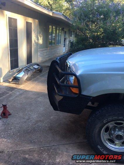 Truck front with aftermarket bumper, detached chrome bumper on ground