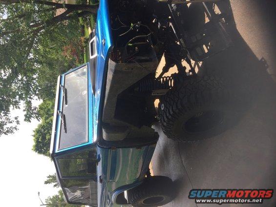 Blue 1974 Ford Bronco with exposed engine and off-road tires
