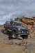 1991 Ford Bronco - This Ford Bronco navigates a challenging rocky trail under a cloudy sky.