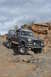 1991 Ford Bronco - This lifted Ford Bronco navigates a challenging rocky trail under a cloudy sky.