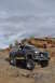 1991 Ford Bronco - A modified Ford Bronco navigates a rocky, off-road landscape under a cloudy sky.