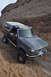 1991 Ford Bronco - This Ford Bronco is navigating a challenging off-road trail with steep, rocky inclines.