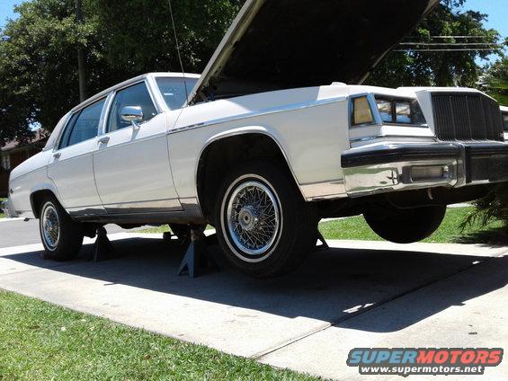 White 1984 Buick Electra on jack stands, hood open, 3/4 front view