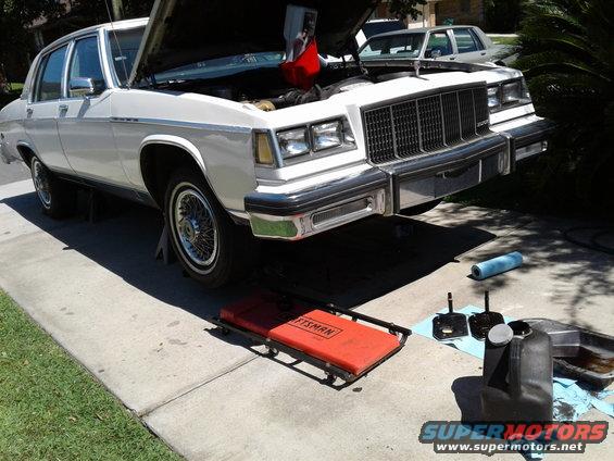 1984 Buick Electra front view, white, hood open, on jack stands