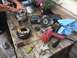 1988 Ford Bronco - Disassembled alternator components and various tools are laid out on a rustic wooden surface, suggesting a repair or rebuild process.