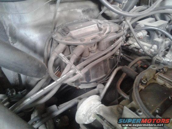 Engine distributor cap with spark plug wires, close-up view