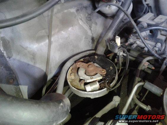 Engine distributor cap with worn contacts and black residue