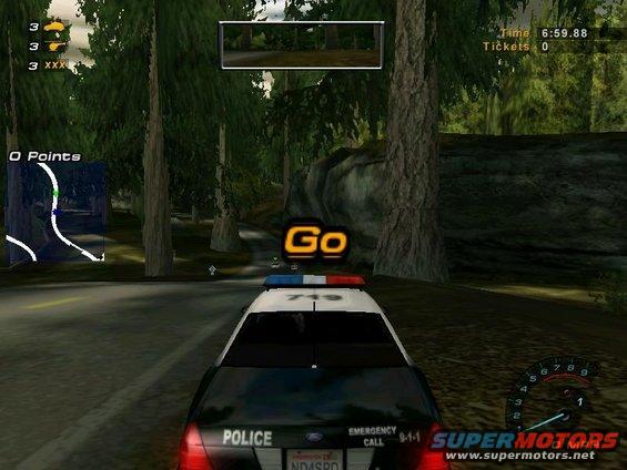 Police car in a video game, driving on a road through trees. Has 'POLICE' on the back