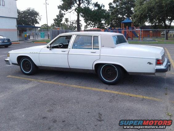 1984 Buick Electra Park Avenue sedan, side view. White exterior, tan vinyl roof