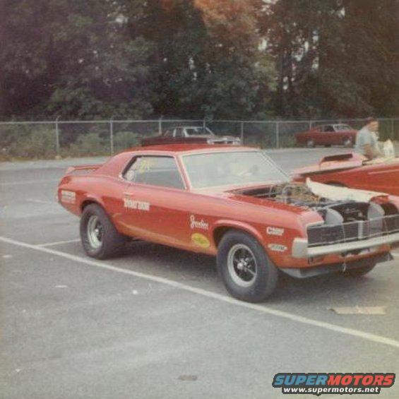 Red 1968 Mercury Cougar drag car with hood open, parked on asphalt