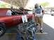 1968 Mercury Cougar - A man looks at a V8 engine displayed next to a classic 1968 Mercury Cougar at an outdoor event.