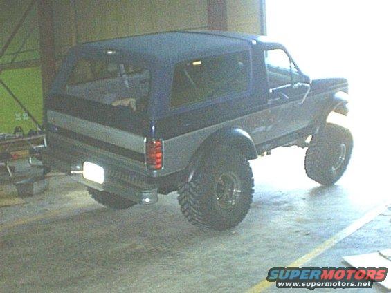 Lifted Ford Bronco with a soft top, parked inside a garage