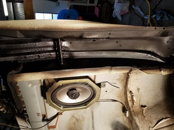 Speaker mounted in car interior panel, showing wiring and surrounding metal structure