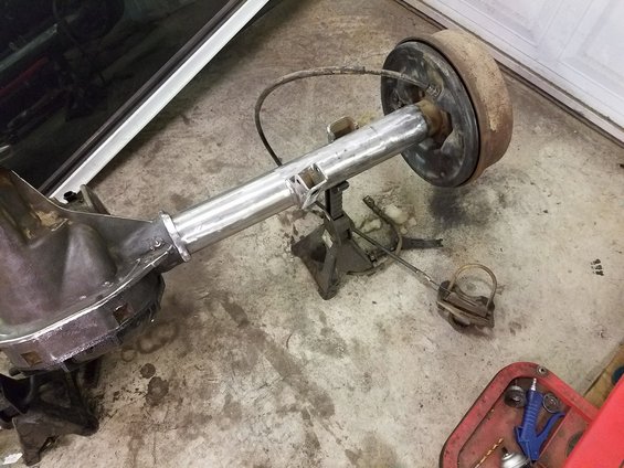 Rear axle assembly on jack stands, showing drum brake and suspension components