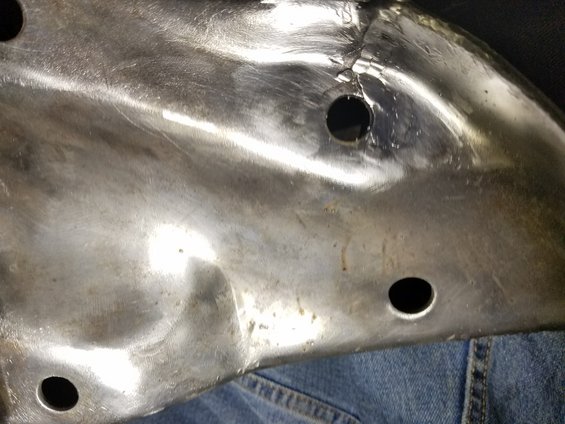 Metal panel with three holes and denim fabric below