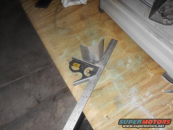 Metal corner bracket with a combination square and ruler on a wooden surface