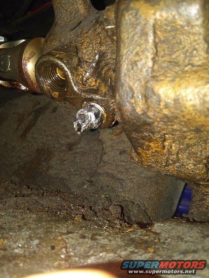 Close-up of a heavily rusted metal component with a broken bolt head