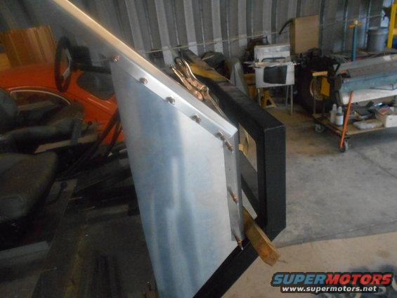Interior view of a vehicle with a metal panel attached to the door frame