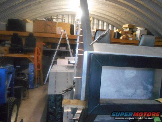 Close-up of a metal structure with a black frame, possibly part of a custom vehicle build, in a workshop setting