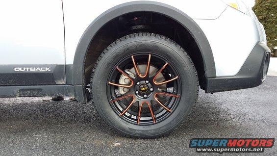 Silver Subaru Outback with aftermarket black and copper wheels, front passenger side wheel visible