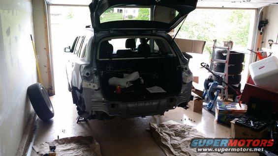 Rear of a 2014 Subaru Outback undergoing repairs in a garage