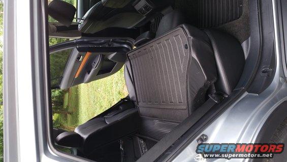 Gray Subaru Outback interior with black leather seats and rubber floor mats. The rear passenger door is open