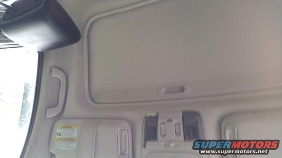 Interior shot of a car's ceiling with a sun visor and grab handle
