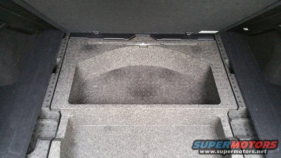 Trunk storage compartment with foam insert and "SUPERMOTORS" watermark
