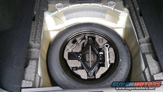 Spare tire, jack, and lug wrench stored in trunk compartment