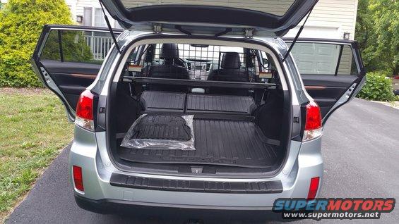 Rear view of a 2014 Subaru Outback with the cargo hatch and rear doors open. The cargo area has rubber floor mats and a cargo divider