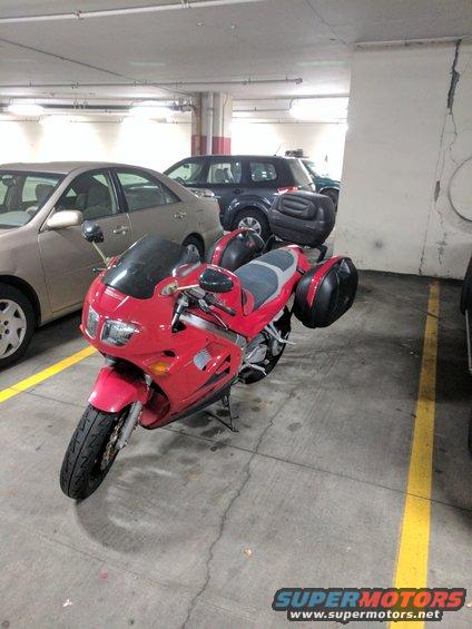 Red motorcycle with saddlebags parked in a garage