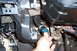1993 Toyota Pickup/SR5 - Close-up of a hand holding a blue relay near the dashboard wiring and steering column of a vehicle.