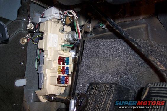 Fuse box with red, blue, and yellow fuses, and textured pedals