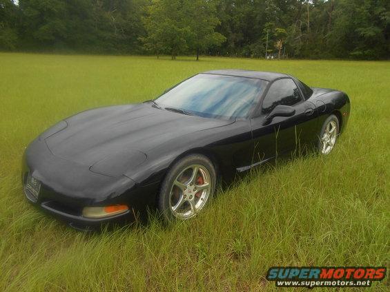Black Chevrolet Corvette C5 parked in a grassy field