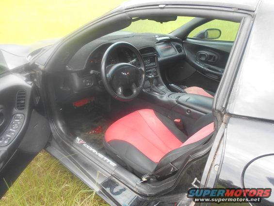 Interior of black sports car with red seats and Corvette badging on door sill