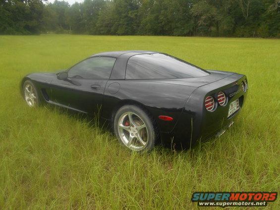 Black Chevrolet Corvette C5 parked in a grassy field