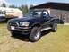 1993 Toyota Pickup/SR5 - This black 1993 Toyota Pickup SR5 is equipped with a brush guard and large off-road tires.