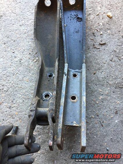 Two metal suspension parts side-by-side, one held by a gloved hand