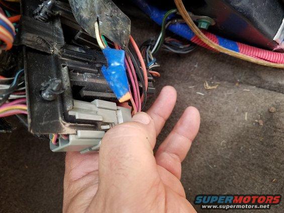 Hand disconnecting wiring harness connector inside 1994 Ford Bronco