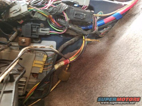 Close-up of tangled vehicle wiring harness with connectors and tape