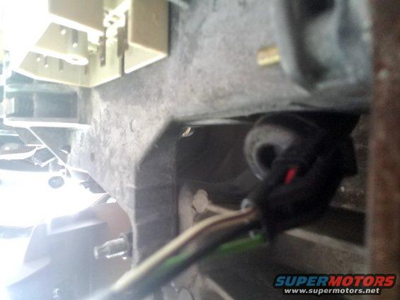 Close-up of a black wiring harness connector with red and green wires