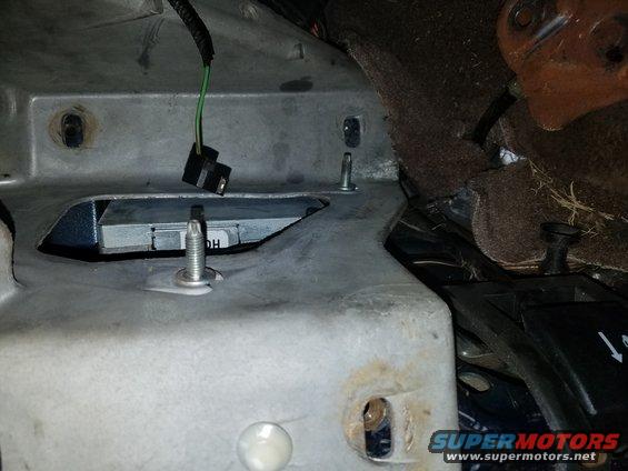 Close-up of vehicle interior metalwork with wiring and a screw. Text 'DH' is visible on a component
