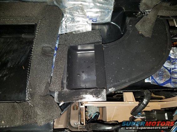 Car interior showing foam insulation and black ductwork, possibly HVAC related