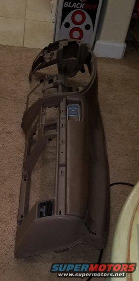 Brown plastic dashboard frame, disassembled, on carpet. A "BLACKOUT" box is visible in the background