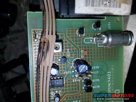 Close-up of a circuit board with wires and electronic components. Text on the board includes '2PEAK9401'