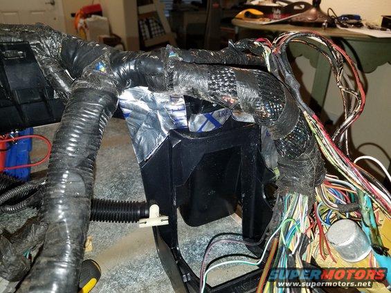Vehicle wiring harness with black tape and exposed wires