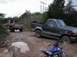 1989 Ford Bronco - Two trucks are stuck in the mud on a dirt path, with an ATV nearby.
