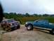 1989 Ford Bronco - Two trucks are navigating a challenging off-road course under an overcast sky.
